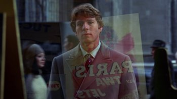 Movie still from “Love Story” (1970), directed by Arthur Hiller – A man wearing a suit and tie standing in front of a window; Close Up shot, Low angle