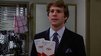 Movie still from “Love Story” (1970), directed by Arthur Hiller – A man wearing a suit and tie holding two tickets in front of a mirror; Close Up shot, Low angle