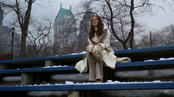 Movie still from “Love Story” (1970), directed by Arthur Hiller – A woman sitting on a bench in the snow; Wide shot, Low angle