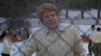 Movie still from “Love Story” (1970), directed by Arthur Hiller – A man in a sweater is standing in the snow; Close Up shot, Over the shoulder angle