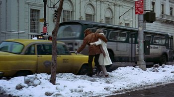 Movie still from “Love Story” (1970), directed by Arthur Hiller – A man and a woman crossing a street in the snow; Wide shot, Low angle