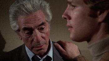Movie still from “Love Story” (1970), directed by Arthur Hiller – An older man in a suit and tie looking at a younger man in a suit and tie; Close Up shot, Over the shoulder angle