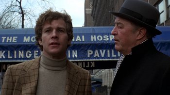 Movie still from “Love Story” (1970), directed by Arthur Hiller – Two men standing in front of a building; Close Up shot, Low angle