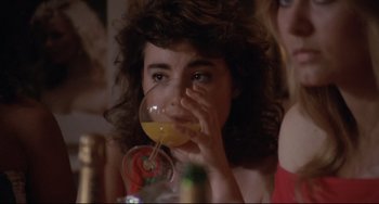 Movie still from “Love Streams” (1984), directed by John Cassavetes – A person drinking a drink from a glass; Close Up shot, Over the shoulder angle