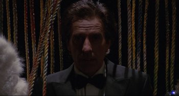 Movie still from “Love Streams” (1984), directed by John Cassavetes – A man wearing a suit and bow tie in front of ropes; Close Up shot, Low angle