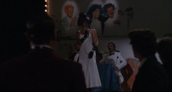 Movie still from “Love Streams” (1984), directed by John Cassavetes – A woman in a white dress is holding a microphone; Wide shot, Over the shoulder angle