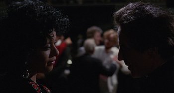 Movie still from “Love Streams” (1984), directed by John Cassavetes – A man and a woman talking to each other in front of a crowd; Close Up shot, Over the shoulder angle