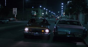 Movie still from “Love Streams” (1984), directed by John Cassavetes – A car driving down a street at night; Wide shot, Low angle