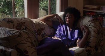 Movie still from “Love Streams” (1984), directed by John Cassavetes – A woman laying on a couch in front of a window; Medium shot, High angle