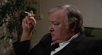 Movie still from “Love Streams” (1984), directed by John Cassavetes – An older man holding a cigarette in his right hand; Close Up shot, High angle