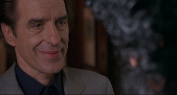 Movie still from “Love Streams” (1984), directed by John Cassavetes – A person wearing a suit and tie; Close Up shot, Over the shoulder angle