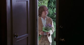 Movie still from “Love Streams” (1984), directed by John Cassavetes – A young boy holding a bouquet of flowers; Medium shot, Over the shoulder angle