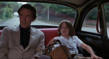 Movie still from “Love Streams” (1984), directed by John Cassavetes – A man and a young boy in a red car; Medium shot, Low angle