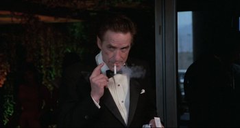 Movie still from “Love Streams” (1984), directed by John Cassavetes – A man in a tuxedo smoking a cigarette; Medium shot, Low angle