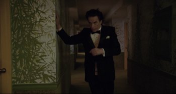 Movie still from “Love Streams” (1984), directed by John Cassavetes – A man in a tuxedo in a dark hallway; Medium shot, Low angle