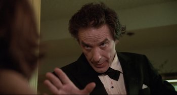 Movie still from “Love Streams” (1984), directed by John Cassavetes – A person wearing a suit and tie; Close Up shot, Low angle