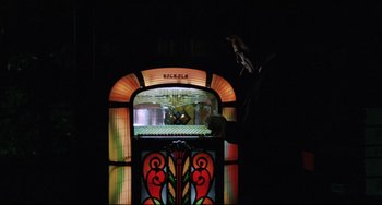 Movie still from “Love Streams” (1984), directed by John Cassavetes – An old jukebox with a bird sitting on top of it; Medium shot, Low angle