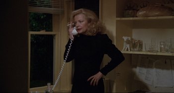 Movie still from “Love Streams” (1984), directed by John Cassavetes – A woman talking on a phone while standing in front of a window; Medium shot, Over the shoulder angle