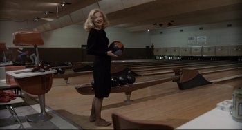 Movie still from “Love Streams” (1984), directed by John Cassavetes – A woman holding a bowling ball in a bowling alley; Wide shot, Low angle