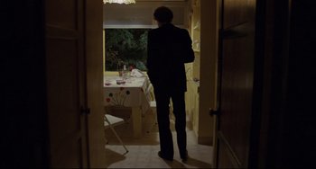 Movie still from “Love Streams” (1984), directed by John Cassavetes – A man standing in front of a dinner table; Wide shot, High angle