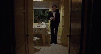 Movie still from “Love Streams” (1984), directed by John Cassavetes – A man in a tuxedo standing next to a table; Wide shot, Low angle