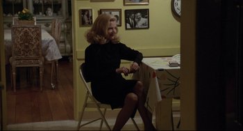 Movie still from “Love Streams” (1984), directed by John Cassavetes – A woman sitting at a table in front of a clock; Medium shot, Over the shoulder angle