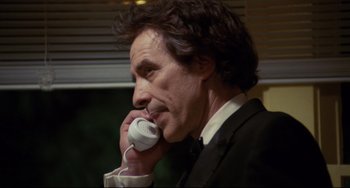 Movie still from “Love Streams” (1984), directed by John Cassavetes – A man in a suit and tie talking on a phone; Close Up shot, Low angle