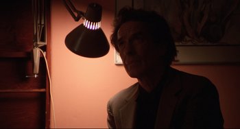 Movie still from “Love Streams” (1984), directed by John Cassavetes – A man standing in front of a lamp in a darkened room; Close Up shot, Low angle