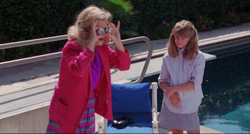 Movie still from “Love Streams” (1984), directed by John Cassavetes – A woman in a pink jacket and a girl in a purple shirt; Medium shot, High angle