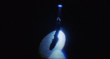 Movie still from “Love Streams” (1984), directed by John Cassavetes – A woman standing in the dark under a blue light; Extreme Wide shot, Overhead angle