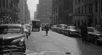 Movie still from “Love with the Proper Stranger” (1963), directed by Robert Mulligan – A man walking across a street in a city; Extreme Wide shot, High angle