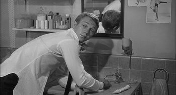 Movie still from “Love with the Proper Stranger” (1963), directed by Robert Mulligan – A black and white photo of a man in the bathroom; Medium shot, Over the shoulder angle