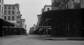 Movie still from “Love with the Proper Stranger” (1963), directed by Robert Mulligan – An old photo of an empty city street; Extreme Wide shot, High angle