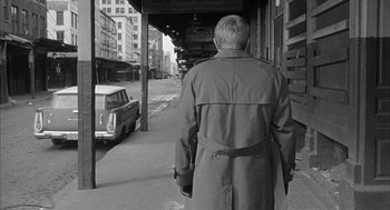 Movie still from “Love with the Proper Stranger” (1963), directed by Robert Mulligan – An older man wearing a trench coat walking down the street; Wide shot, Over the shoulder angle