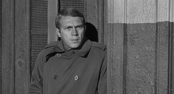 Movie still from “Love with the Proper Stranger” (1963), directed by Robert Mulligan – Black and white photograph of a man wearing a trench coat; Close Up shot, Low angle