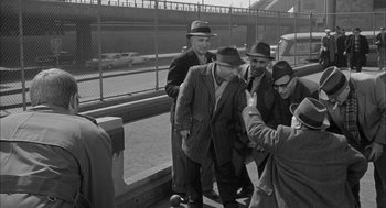 Movie still from “Love with the Proper Stranger” (1963), directed by Robert Mulligan – A black and white photo of a group of men standing next to each other; Wide shot, High angle