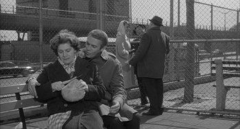 Movie still from “Love with the Proper Stranger” (1963), directed by Robert Mulligan – An old black and white photo of a man and a woman; Medium shot, High angle