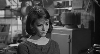 Movie still from “Love with the Proper Stranger” (1963), directed by Robert Mulligan – A black - and - white photo of a woman in a kitchen; Close Up shot, Over the shoulder angle