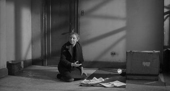 Movie still from “Love with the Proper Stranger” (1963), directed by Robert Mulligan – An older woman sitting on the floor in front of an open door; Wide shot, High angle