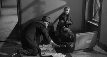 Movie still from “Love with the Proper Stranger” (1963), directed by Robert Mulligan – A man and a woman sitting on the ground; Medium shot, High angle