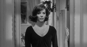 Movie still from “Love with the Proper Stranger” (1963), directed by Robert Mulligan – A black and white photo of a woman in a black dress; Medium shot, Over the shoulder angle