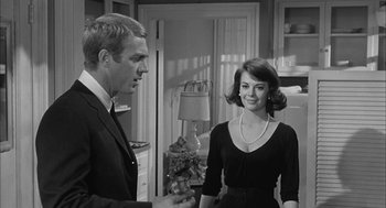 Movie still from “Love with the Proper Stranger” (1963), directed by Robert Mulligan – A man and a woman standing in a kitchen; Medium shot, Over the shoulder angle