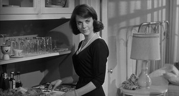 Movie still from “Love with the Proper Stranger” (1963), directed by Robert Mulligan – Black and white photograph of a woman in a black dress; Medium shot, Low angle