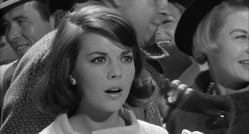 Movie still from “Love with the Proper Stranger” (1963), directed by Robert Mulligan – A black - and - white photo of a woman in front of a microphone; Close Up shot, Over the shoulder angle