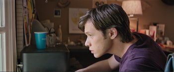 Movie still from “Love, Simon” (2018), directed by Greg Berlanti – A young man sitting at a table looking off to the side; Close Up shot, Over the shoulder angle