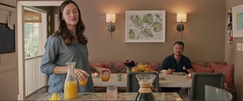 Movie still from “Love, Simon” (2018), directed by Greg Berlanti – A woman pouring orange juice into a pitcher; Medium shot, Over the shoulder angle