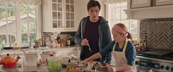 Movie still from “Love, Simon” (2018), directed by Greg Berlanti – A young man and a little girl preparing food; Medium shot, Over the shoulder angle