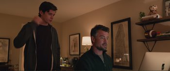 Movie still from “Love, Simon” (2018), directed by Greg Berlanti – Two men in a living room looking at something on the wall; Medium shot, Low angle