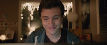 Movie still from “Love, Simon” (2018), directed by Greg Berlanti – A young man smiling with his eyes closed; Close Up shot, Over the shoulder angle