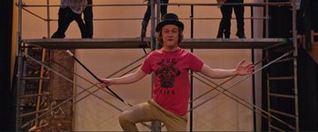 Movie still from “Love, Simon” (2018), directed by Greg Berlanti – A man wearing a top hat and holding a cane; Medium shot, Low angle